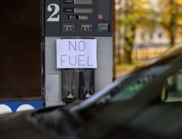 Gas pump with a handwritten sign reading 'NO FUEL' taped over the nozzle area, indicating no available fuel at the station
