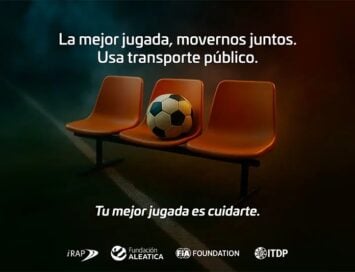 Three orange stadium seats with a soccer ball on the middle seat against a dark gradient background; Spanish PSA urging using public transport and staying safe: 'La mejor jugada, movernos juntos. Usa transporte público. Tu mejor jugada es cuidarte.'