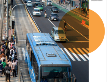 Busy urban street with a blue bus, cars, and pedestrians, illustrating a policy brief on electrified compact cities.