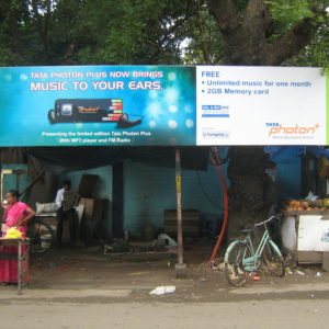The public transport bus stop is encroached upon by street vendors.