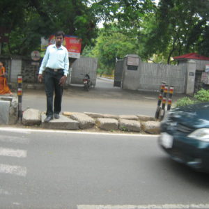 Pedestrian trying to cross a busy road in Chennai.